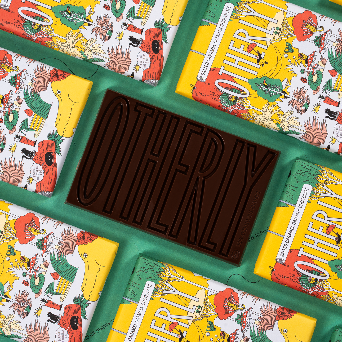 Chocolate bars with colorful packaging featuring the brand 'Otherly' on a green surface.