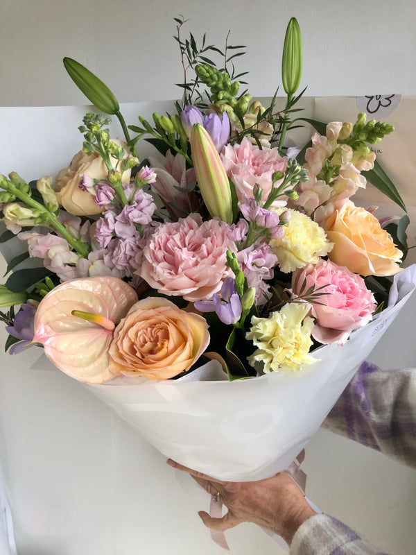 Pastel flowers shop bouquet in white wrap