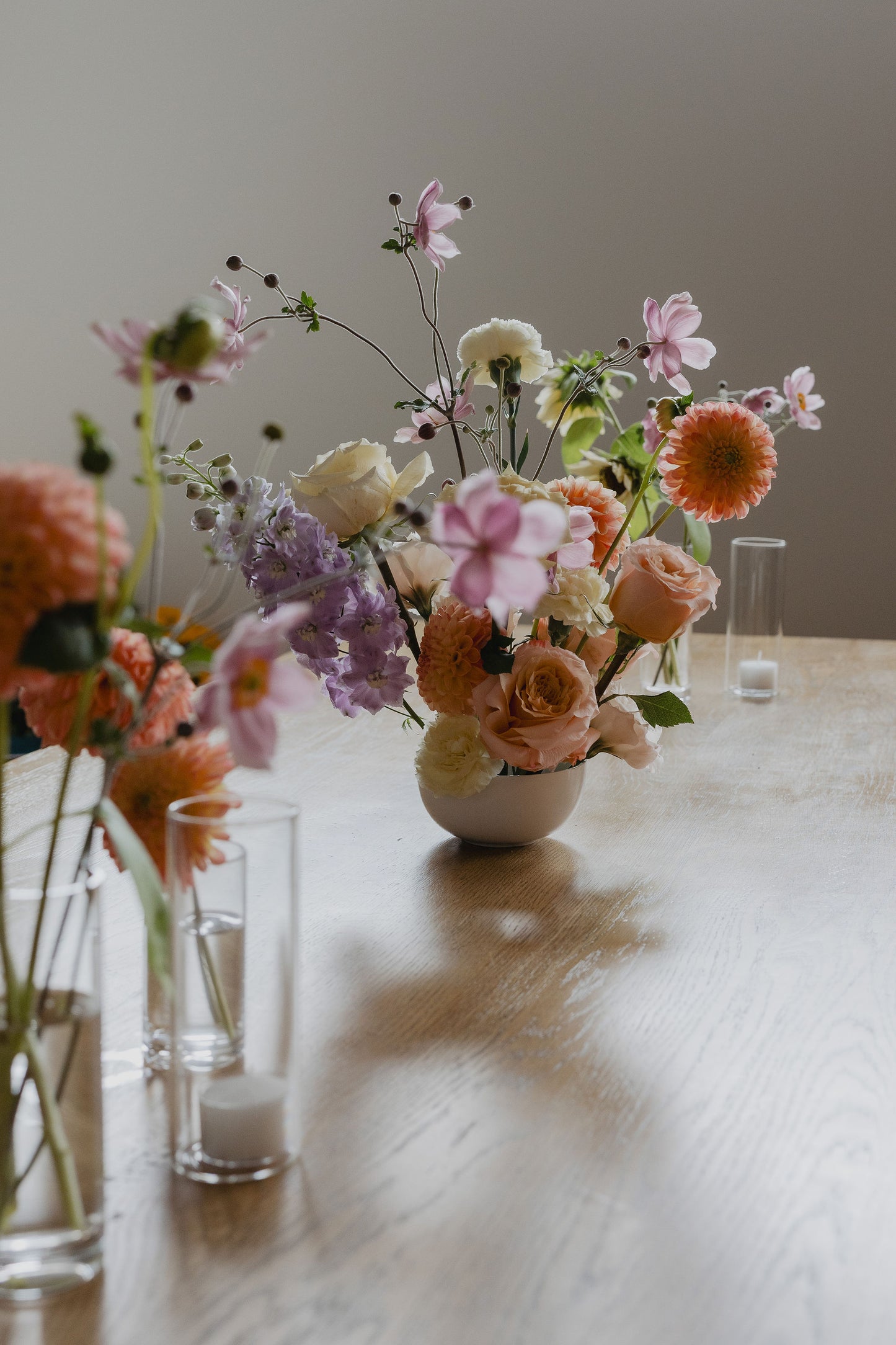 Floral arrangement in a vase on a wooden table with a neutral background