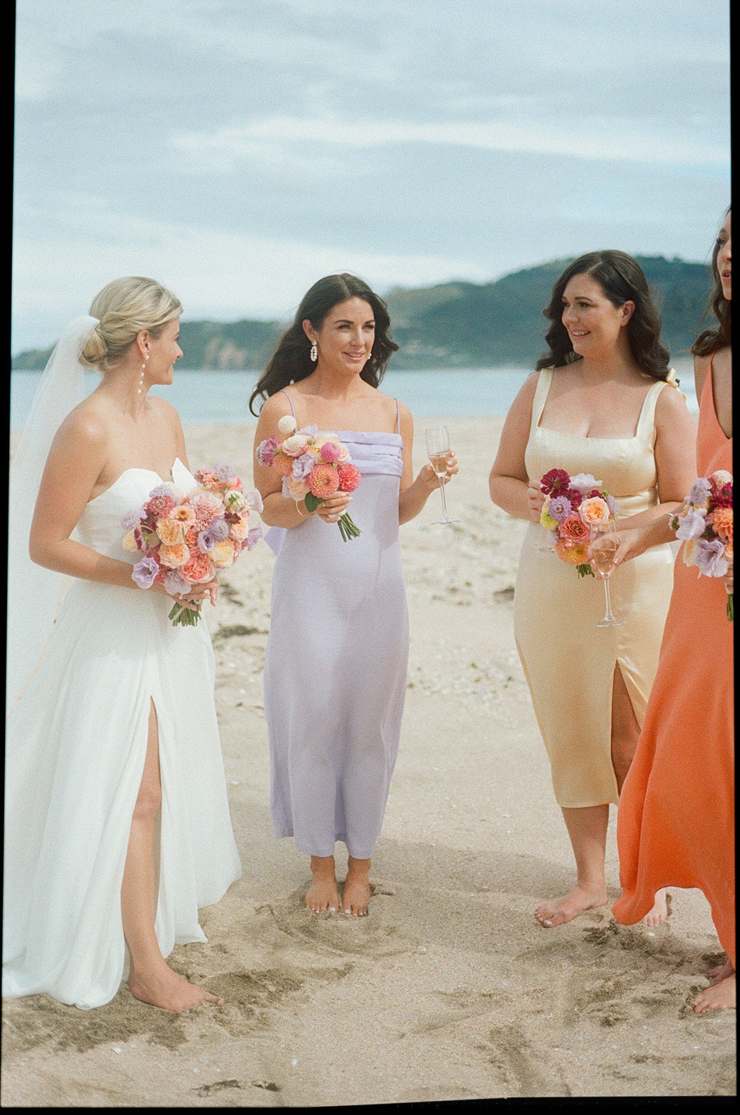 Group of women on a beach with floral bouquets